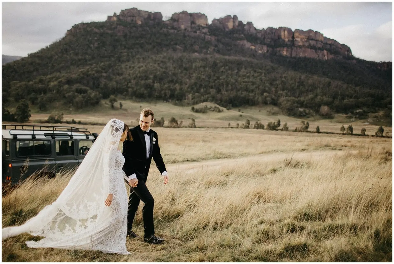 Tom & Josslyn at Emirates One&Only Wolgan Valley: The couple stand in a field beneath the escarpment.