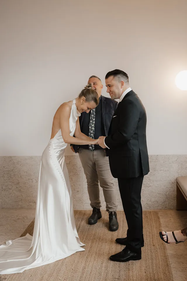 Clare and Matt exchanging rings in their suite with celebrant Josh Withers.