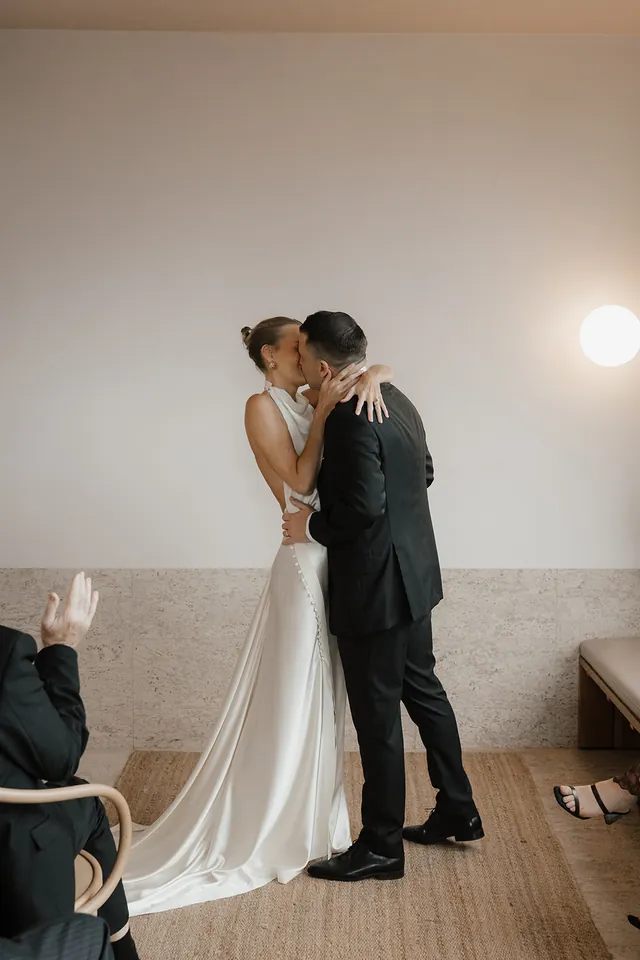 Clare and Matt kissing at the end of their ceremony in The Calile suite.
